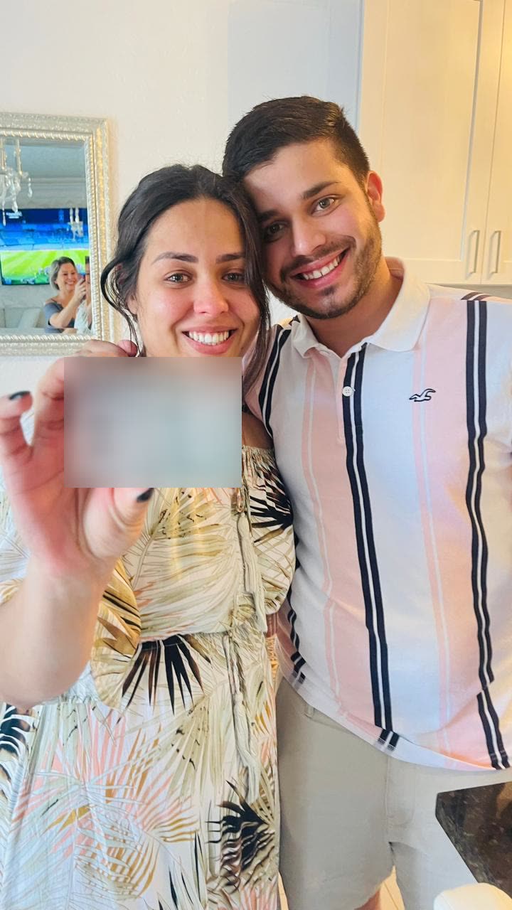 Casal cliente da SOS Direito comemorando em casa a chegada do documento