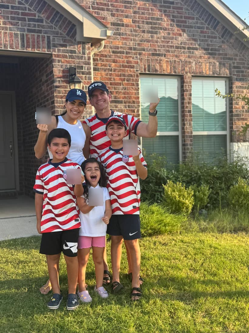 Família de cinco em frente à casa nova, com camisas da seleção dos Estados Unidos